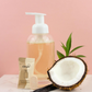 Glass, foaming hand soap dispenser containing peach coloured Nature Bee hand soap.