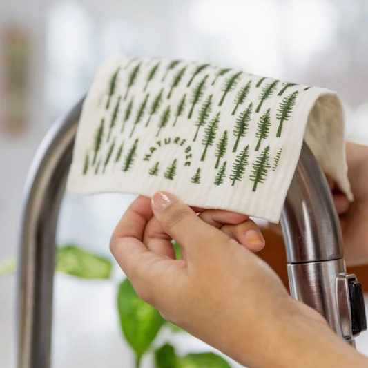 Nature Bee pine tree patterned Swedish dishcloth drying over faucet head.